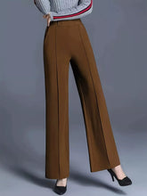 Brown wide-leg pants with a tailored fit and subtle vertical pleats featuring easy care instructions for tumble dry
