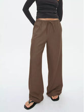 Brown wide leg drawstring pants featuring an elastic waistband and comfortable wide leg design