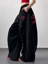 Black wide leg casual pants featuring red heart and script embroidery ideal for stylish everyday wear