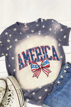Patriotic America round neck short sleeve t-shirt with bleached blue fabric, white stars, red white blue AMERICA text, and bow