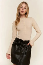 Beige ribbed long sleeve bodysuit with button front and ruffled cuffs featuring a half button round neck design