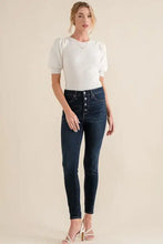 Dark wash high-rise skinny jeans with button fly and five silver buttons paired with puffed half sleeve rib bodysuit