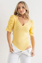 A vibrant yellow sleeve bodysuit with shirring puff sleeve detail and a flattering scoop neckline