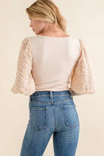 A cream-colored puff sleeve bodysuit with textured puff sleeves and a ribbed back side view