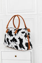 Animal print brushed weekender bag with cow print and tan leather handles