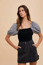 Annie Wear cargo denim mini skirt in black featuring front pockets and button closure in durable denim material