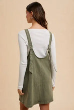 Annie wear olive green adjustable strap denim overall dress with v-neck, relaxed fit, and pockets