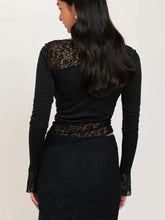 Black long sleeve top with sheer floral lace detailing on shoulders waistband and cuffs in asymmetric panels design