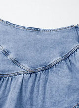 A light blue denim mini skirt with an asymmetric ruffle hem and visible stitching details