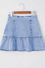Light blue denim mini skirt with asymmetric tiered ruffle hem and front panel stitching in soft denim material