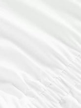 White quilted fabric with subtle diagonal stitching on an asymmetrical button long sleeve shirt detail