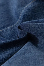 Dark blue asymmetrical denim skort with high waist, pockets, and textured wash