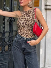 Vibrant red leather crossbody bag with silver hardware displayed with asymmetrical neck leopard bodysuit product