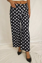 Black mid-rise wide-leg trousers with bold white polka dot print and patched pockets for stylish everyday wear polka dot pants