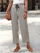 Black and white vertically striped wide-leg high-waisted cropped pants with drawstring waistband for casual wear