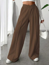 Brown wide leg high waist pants with elastic waistband and relaxed flowing silhouette in lightweight fabric