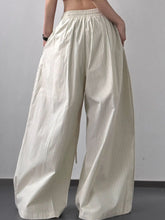 Cream-colored striped wide leg drawstring pants with subtle vertical stripes and elastic waistband for comfort