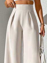Cream-colored wide leg high waist pants with sleek pleated front and smooth fabric for elegant wear