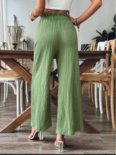 High-waisted light green wide leg pants with pleated texture and elastic waistband for comfortable wear