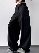 Black wide leg cargo pants with large flap pockets and buttoned waistband in durable fabric for versatile wear