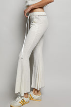 Cream-colored flared pants with a drawstring waistband and side pockets in textured ribbed knit fabric