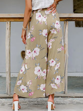 Beige tied waist slit floral wide leg pants with pink and white hibiscus flowers on lightweight fabric