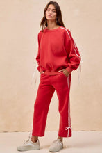 Red oversized sweatshirt with white side stripes and bow details fleece drawstring ties at the cuffs