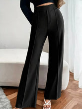 Black high waist flare pants with wide-leg tailored fit and subtle front pleats for a sleek look
