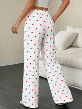 White wide leg pants with red heart print drawstring waist and vertical pleats in a lightweight fabric