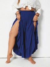 Plus size royal blue ruffled wide leg pants with flowing fabric, high side slits, and a ruffled hem
