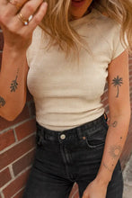 Cream ribbed textured crew neck cap sleeve slim top with black jeans and palm tree tattoo