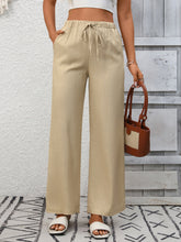 Beige drawstring high waist wide leg pants made of lightweight fabric with elastic waistband for comfortable wear
