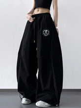 Black wide leg drawstring pants with silver embroidered heart design on the thigh in soft fabric