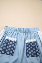Light blue denim skirt with white lace accent floral trim and snowflake-patterned accent floral patched pockets
