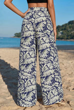 High-waisted leaf print wide leg pants in navy blue and light green tropical leaf print made from lightweight fabric