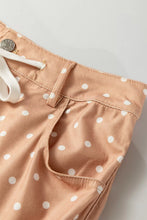 Beige polka dot print cotton shorts with white drawstring and metal button in a wide leg drawstring design