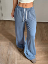 Light blue drawstring wide leg pants with adjustable drawstring waist made from soft, loose-fitting fabric