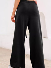 Black tied elastic high waist wide-leg sweatpants with pleated detail and subtle side slit for comfortable wear