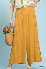 Honey-colored umgee linen wide leg pants with elastic waistband and frayed side pocket detail