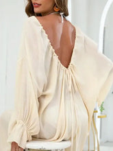 Woman in backless drawstring flounce sleeve cream top