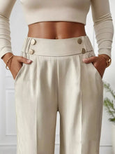 Cream-colored full size high-waisted wide-leg pants with sleek satin finish and three metallic buttons on waistband