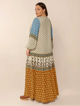 Plus size printed balloon sleeve maxi dress with tiered patterned panels in blue, cream, and rust