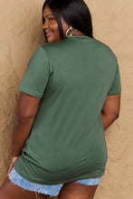 Simply Love mom life graphic short sleeve cotton t-shirt in olive green with frayed denim shorts and hoop earrings