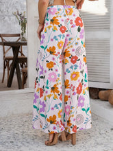 Floral print devine drawstring pants with wide-leg design in vibrant orange pink purple and green on light background care instructions included