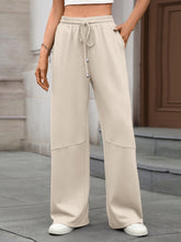 Beige drawstring high waist wide leg casual pants with elastic waistband and subtle seam detailing in a relaxed fit