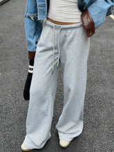 Light gray wide leg drawstring sweatpants made of soft fabric with a loose fit and adjustable waistband care instructions included