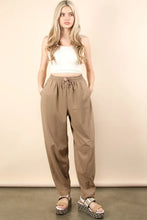 Beige solid barrel comfy woven pants with drawstring waist, relaxed tapered fit, and subtle side seam detailing