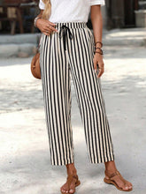 Black and white vertically striped wide-leg cropped pants with a high-waisted drawstring waistband