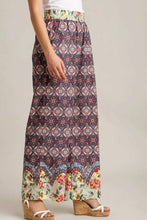 Umgee plus size flowing maxi skirt in maroon mixed print fabric with colorful elastic waistband and floral hem trim