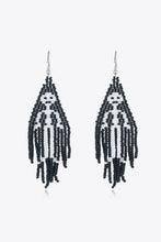 Black and white beaded dangle earrings with striped human figure